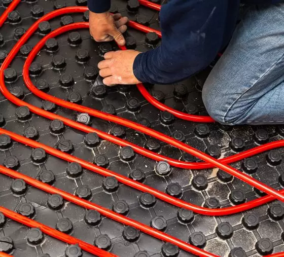 A technician installing radiant in-floor heating