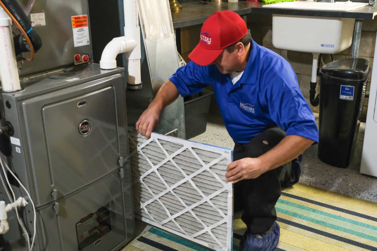 Masters Heating & Cooling technician replacing an HVAC air filter