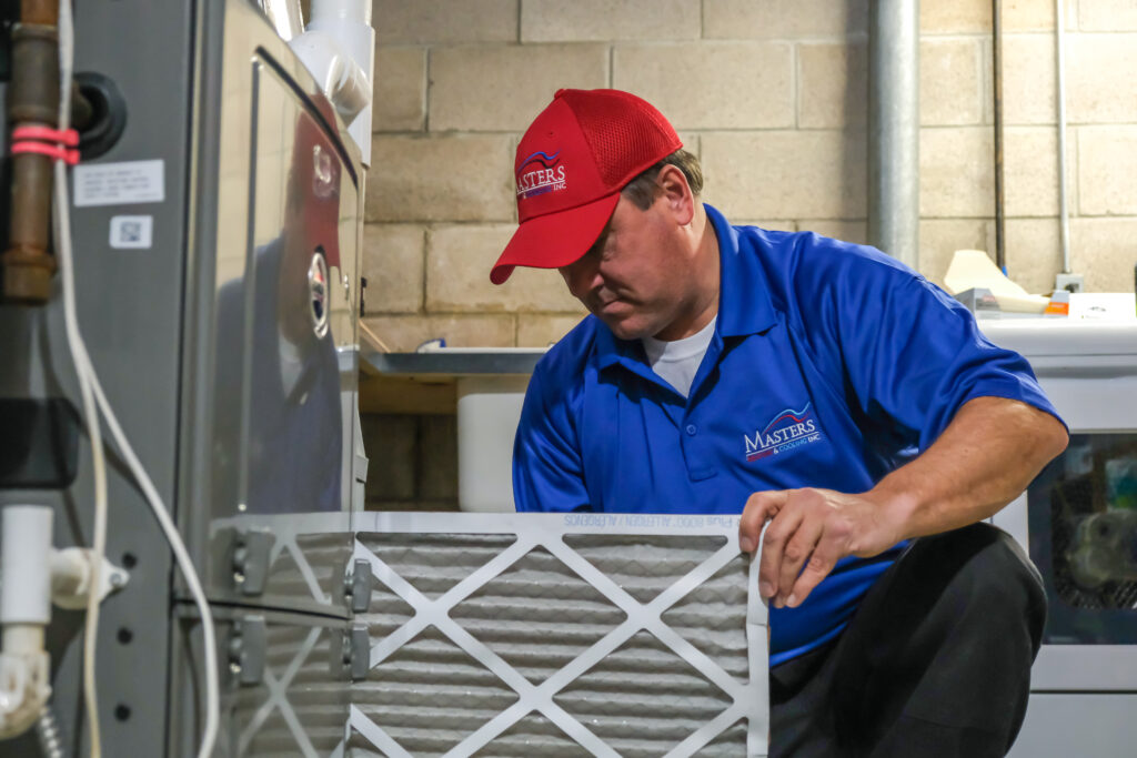 Masters Heating & Cooling technician replacing a furnace air filter