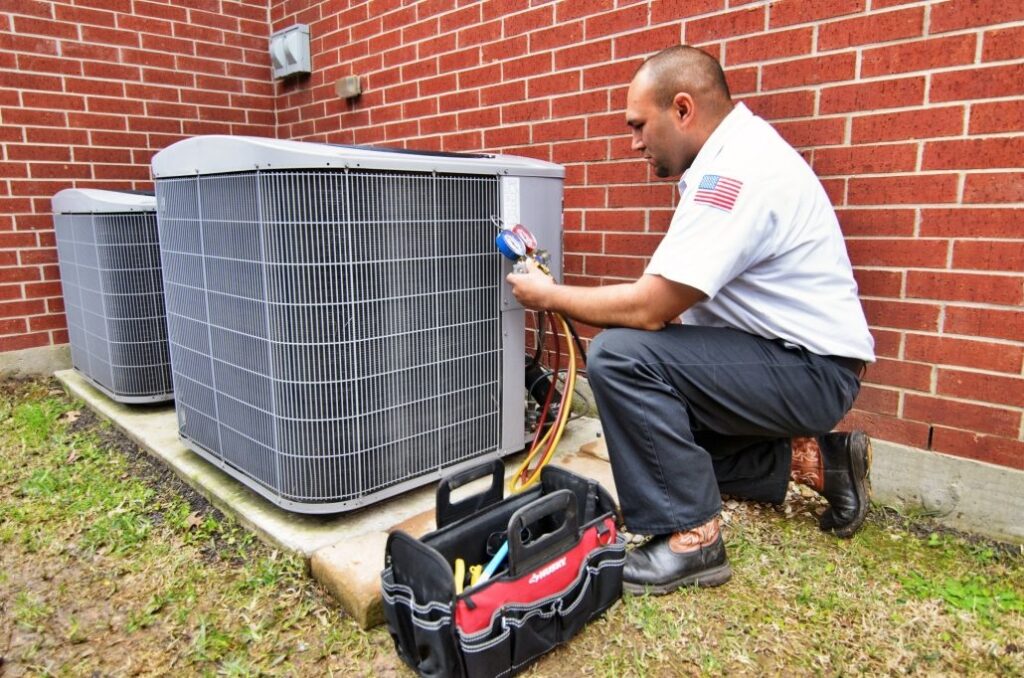 AC technician performing a service on an outdoor residential HVAC unit
