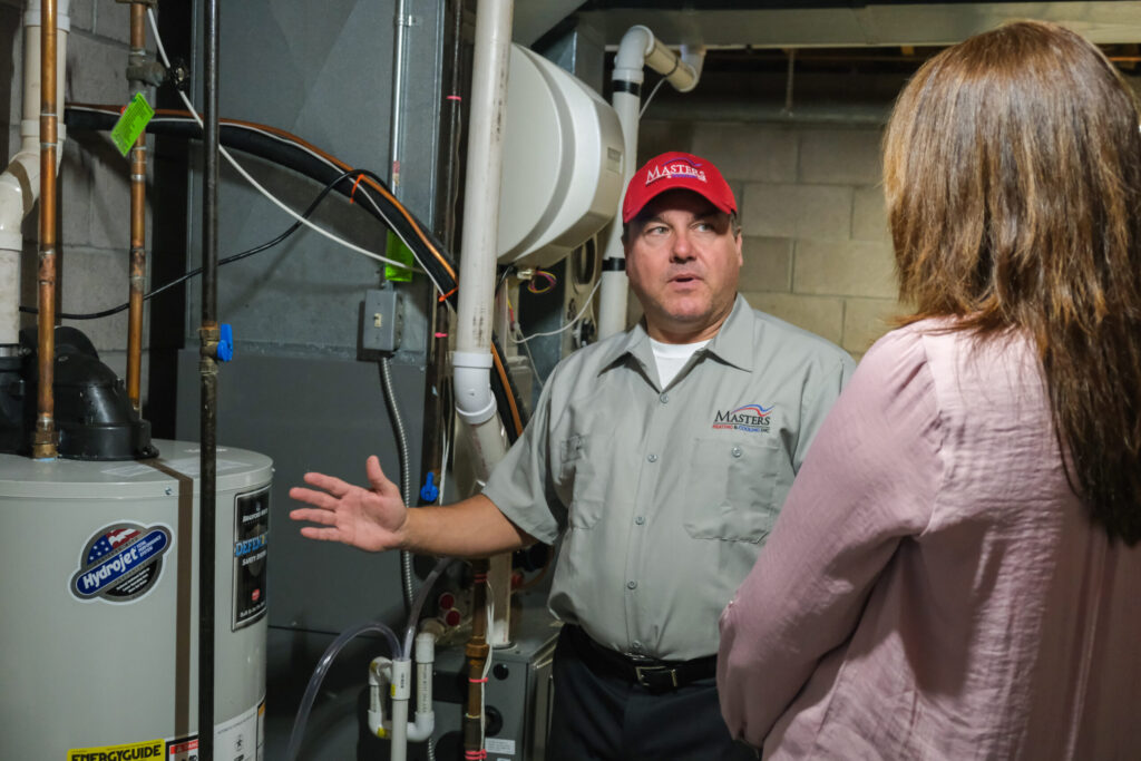 Masters Heating & Cooling technician performing maintenance on an HVAC system.