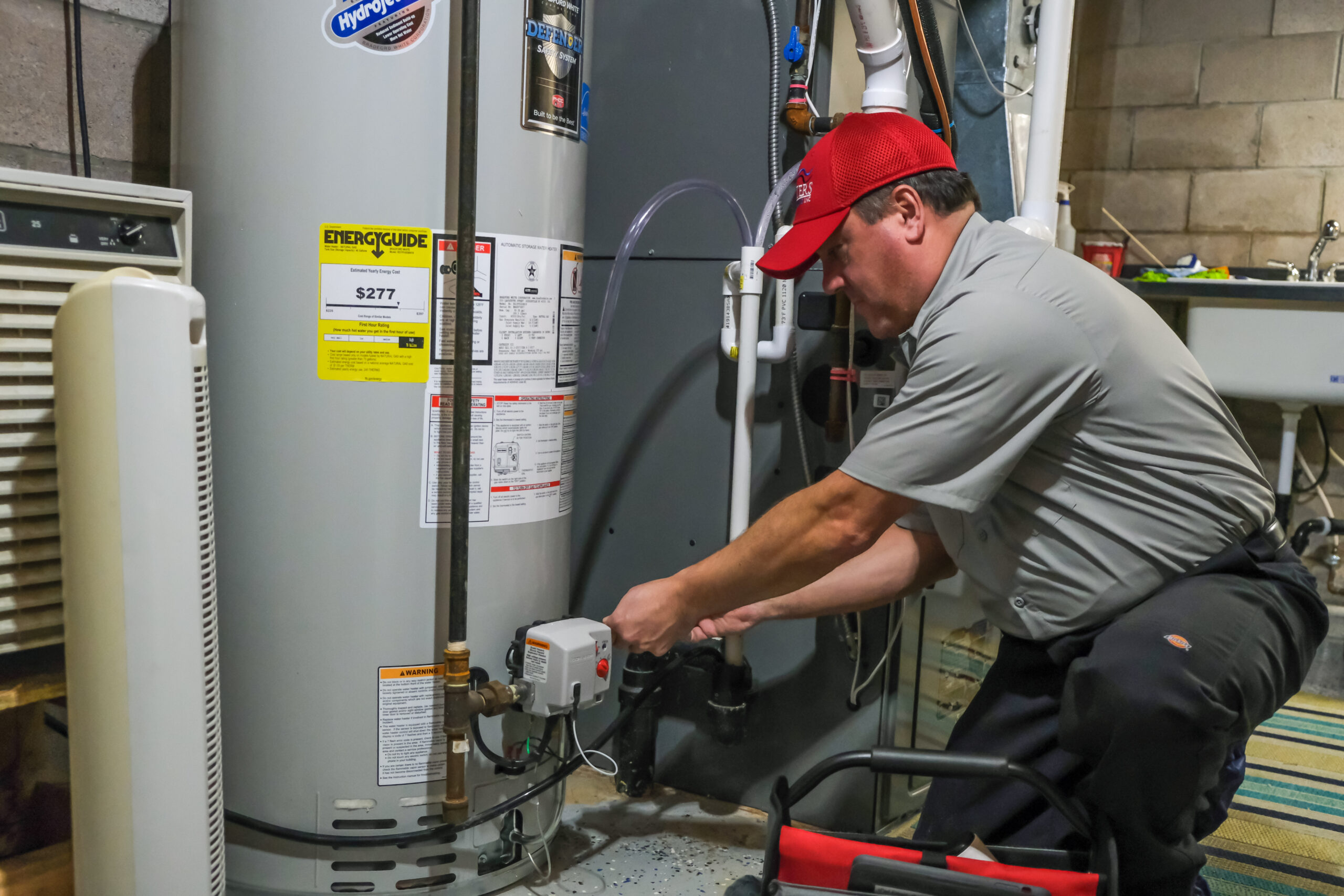 Masters Heating & Cooling technician working on a residential water heater