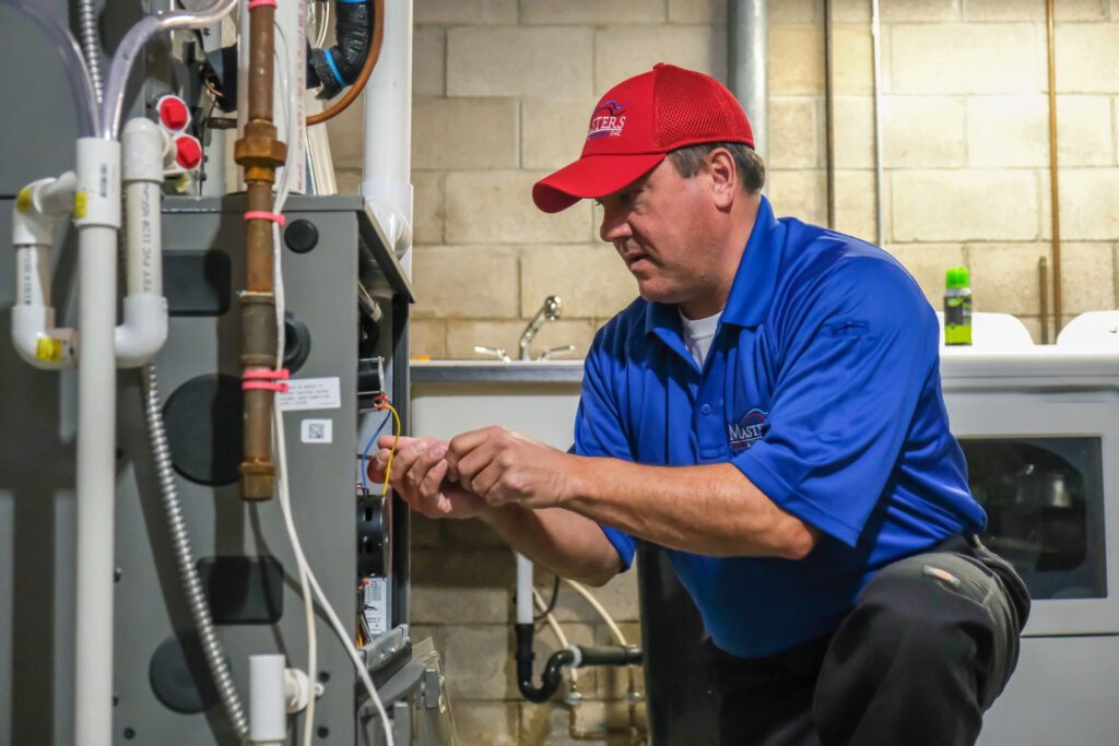 Masters Heating & Cooling technician fixing a residential furnace