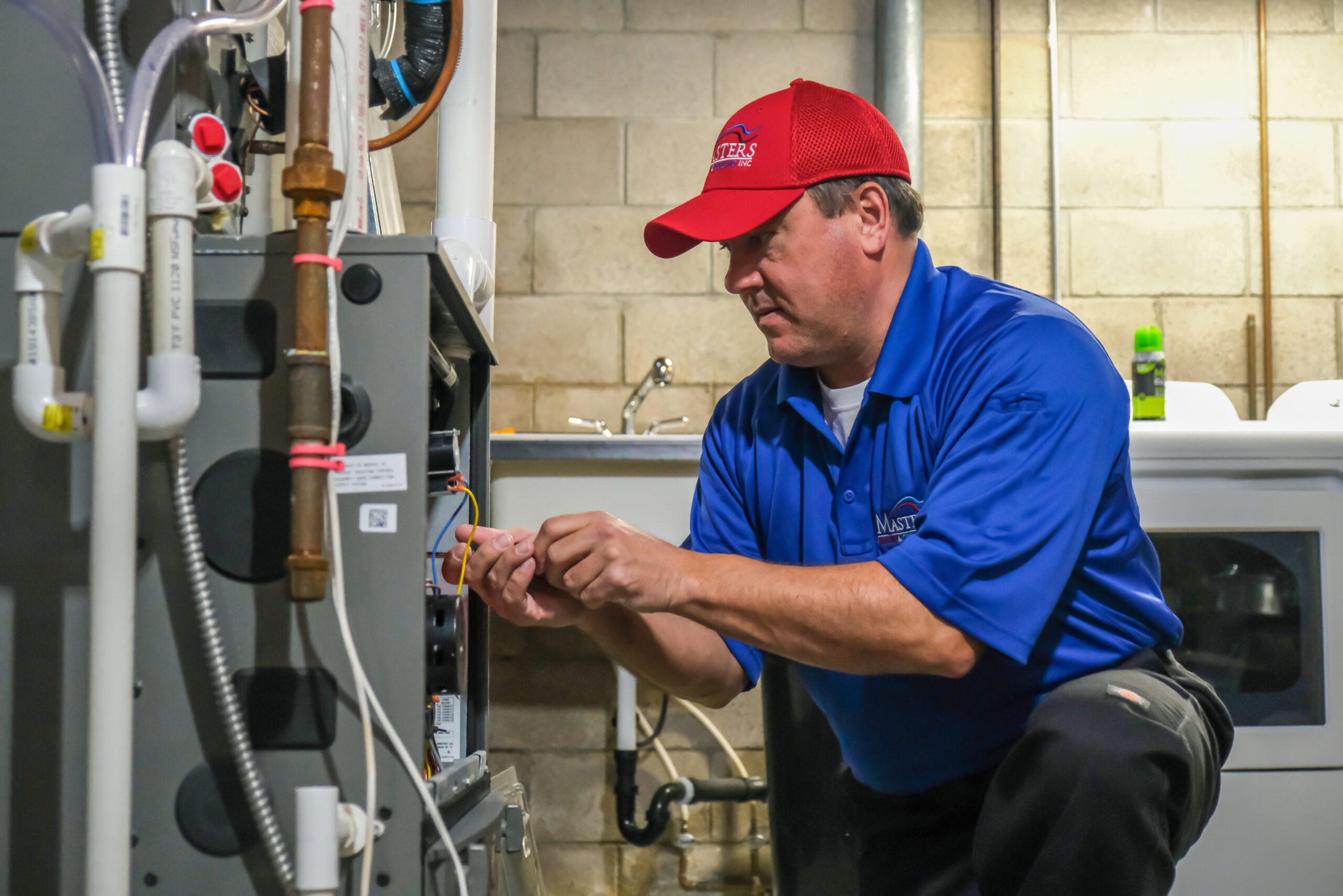 Masters Heating & Cooling technician repairing a home’s furnace