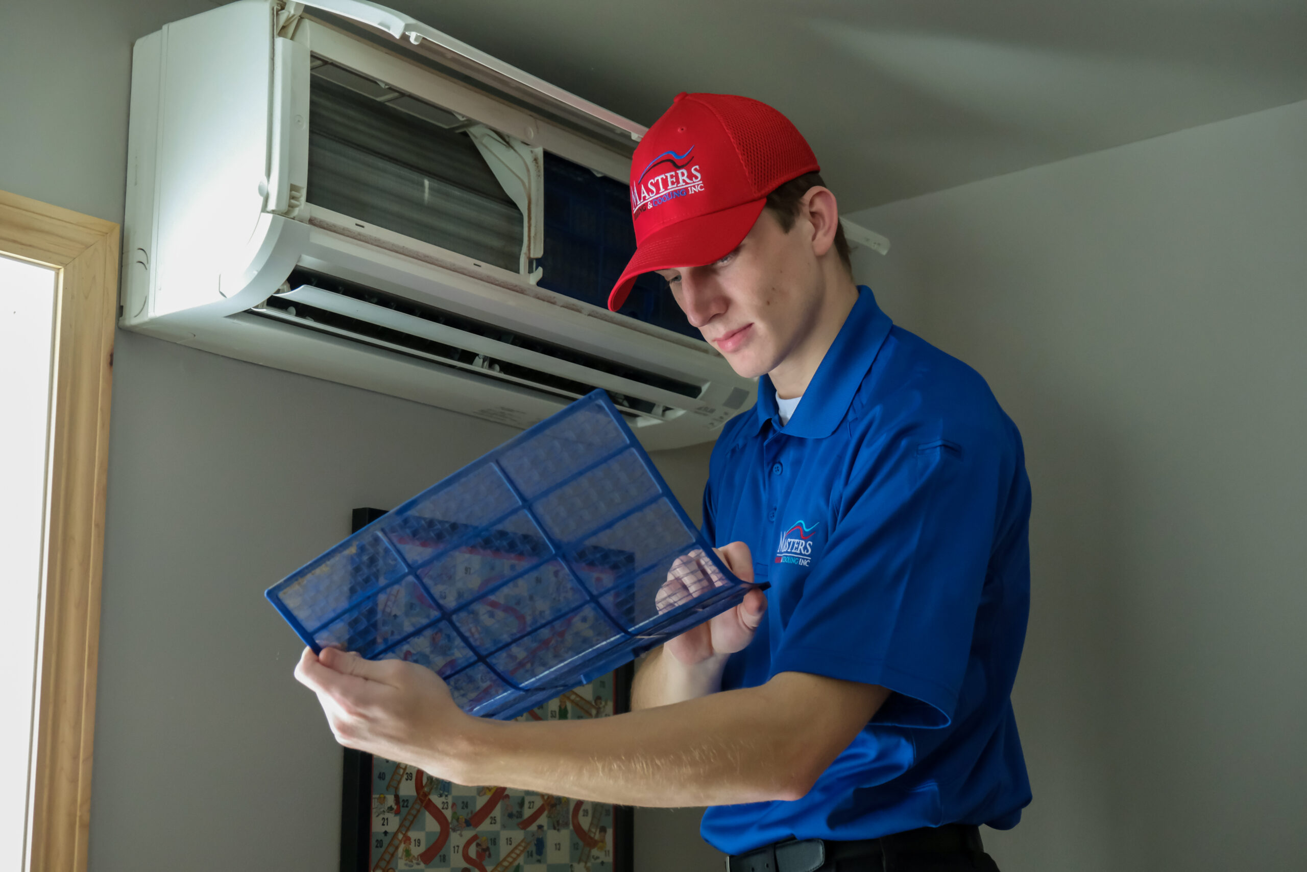 Masters Heating & Cooling technician servicing a home's ductless AC