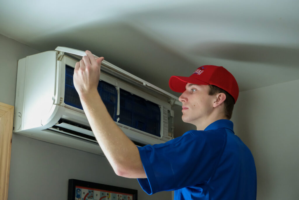 Masters Heating & Cooling technician inspecting a ac unit during a service call.