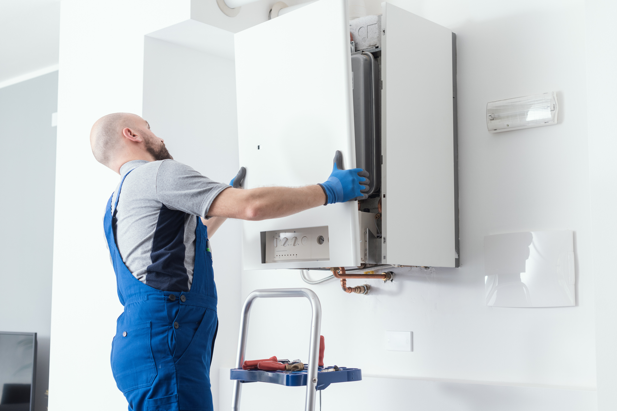 HVAC technician taking the front panel off a home’s boiler