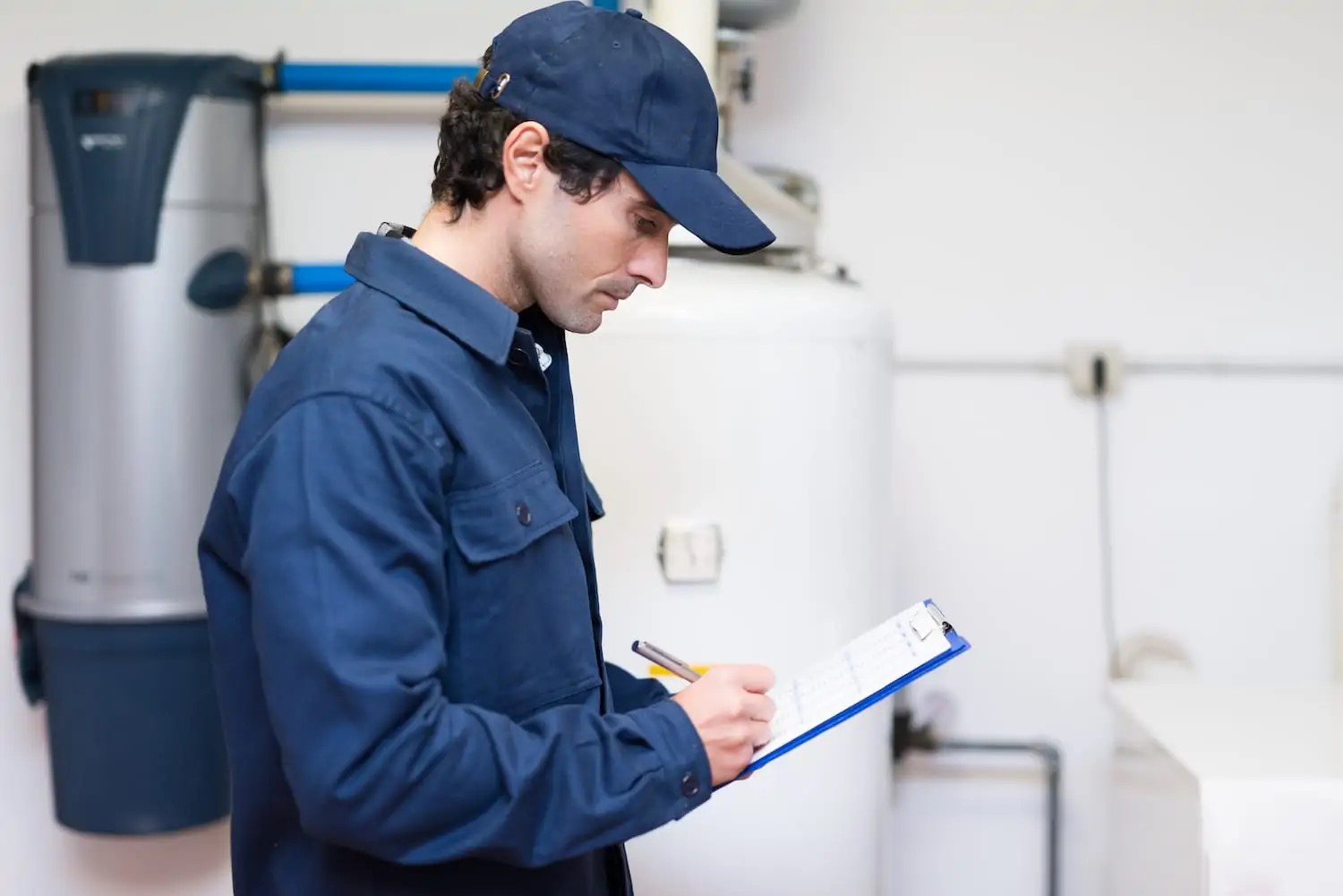 Plumber standing in front of newly installed residential water heater