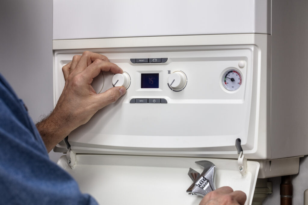 Plumber performing annual maintenance on a residential boiler