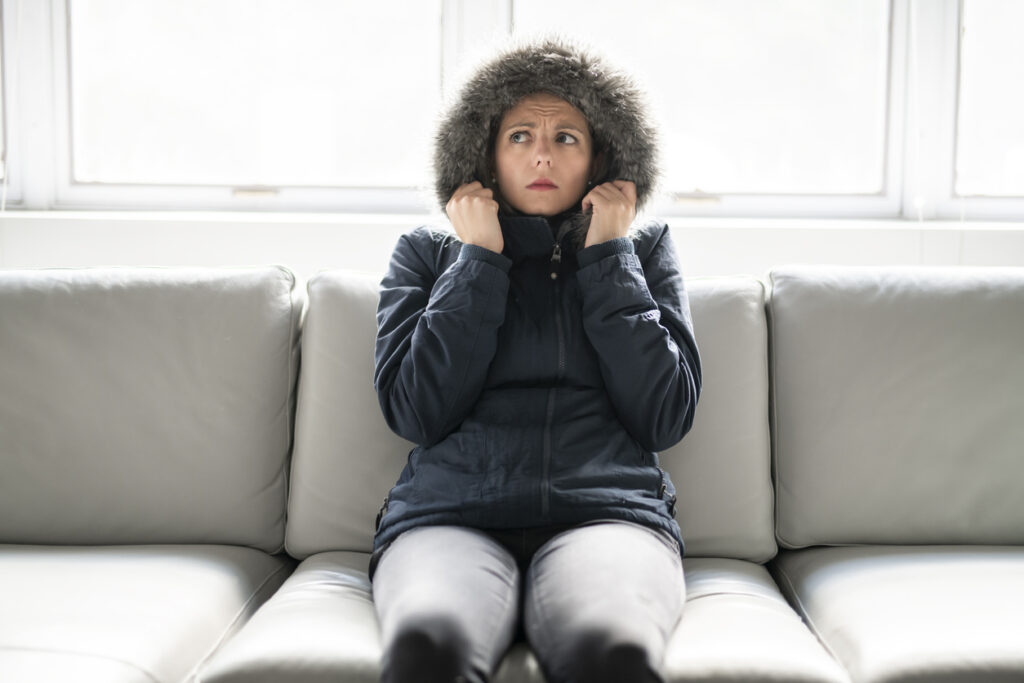 Woman wearing parka inside when furnace is broken