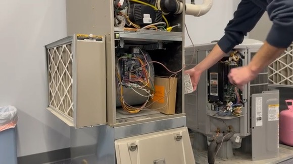 Masters Heating, Cooling, Plumbing & Electrical technician replacing a furnace air filter